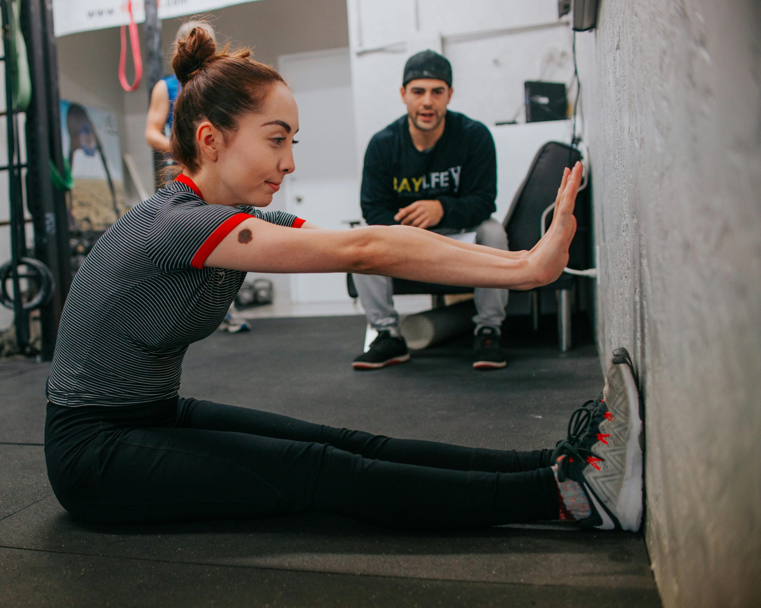 Een persoon die online fitnessinstructies volgt op een laptop.